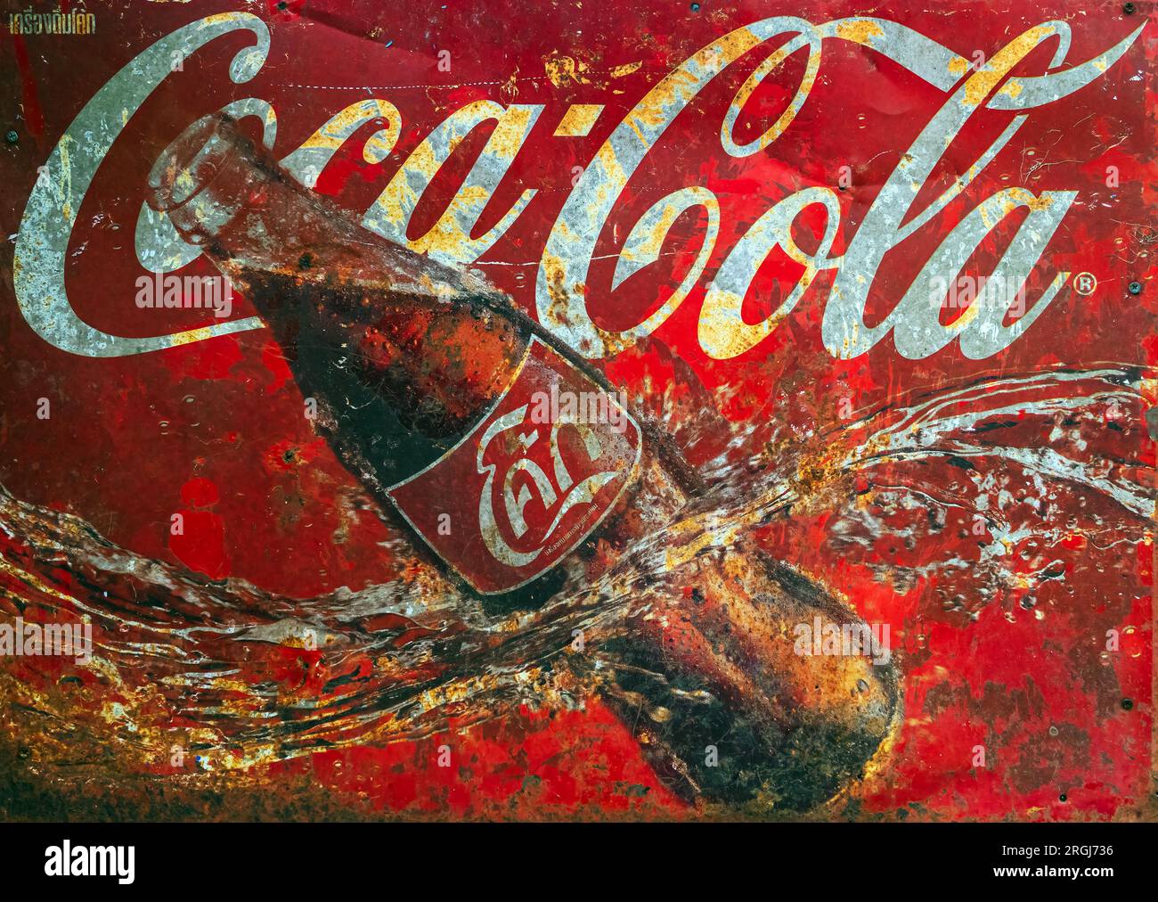 KANCHANABURI, THAILAND - JUNI 28,2023: Nahaufnahme des klassischen Coca-Cola-Logo-Banners, alte rostige und zerbrochene Zinkplatte der Coke-Softdrink-Werbung Stockfoto