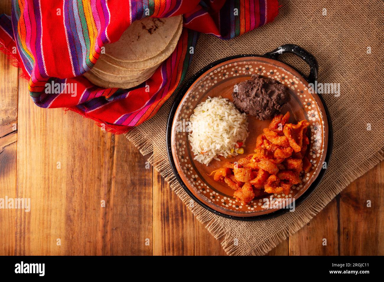 Chicharron en Salsa roja. Schweineschalen in roter Sauce, dazu Reis und gekühlte Bohnen. Traditionelles hausgemachtes Gericht, sehr beliebt in Mexiko, dies Stockfoto