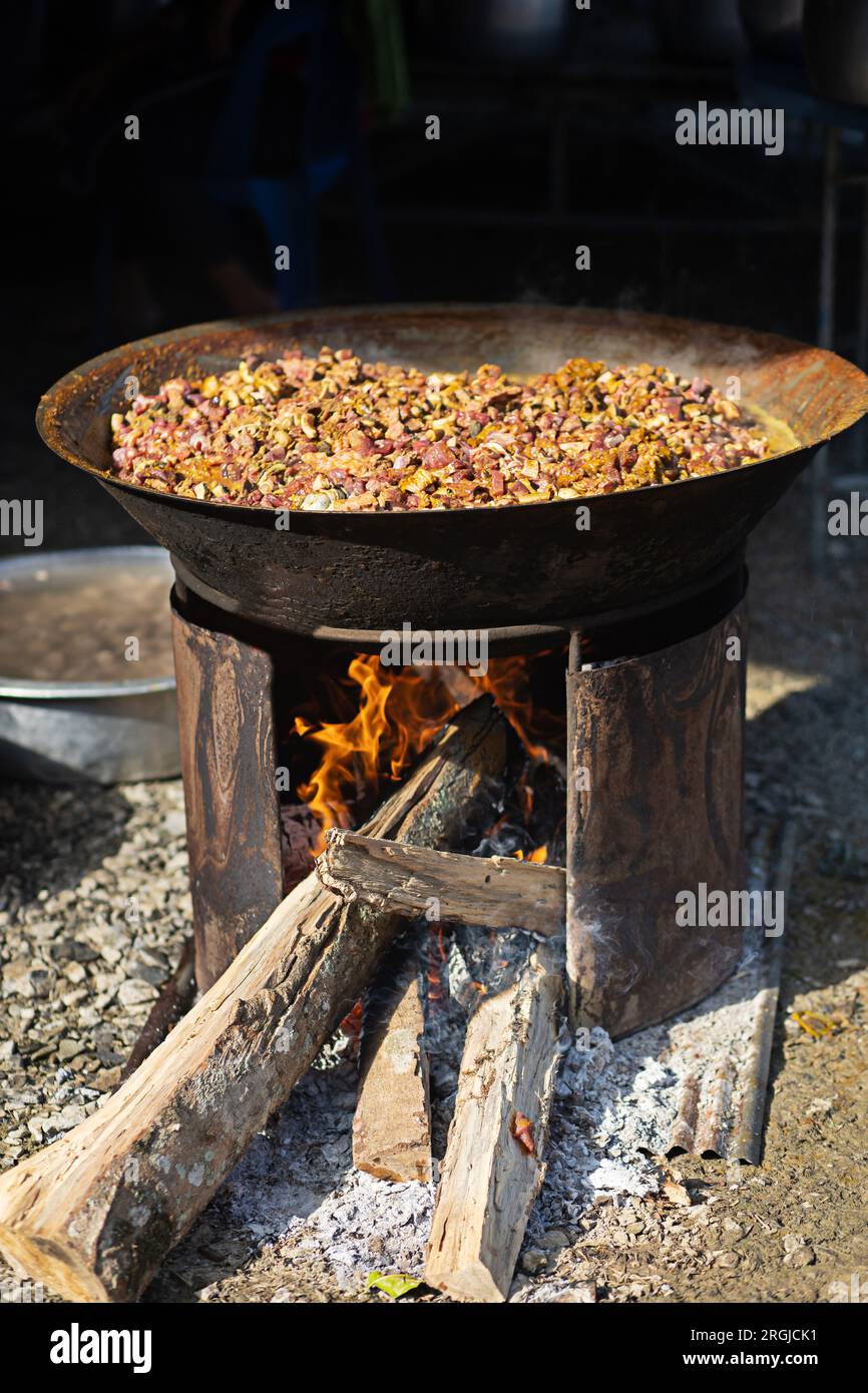 Kochen mit einem Kohleofen und einer großen Pfanne Stockfoto
