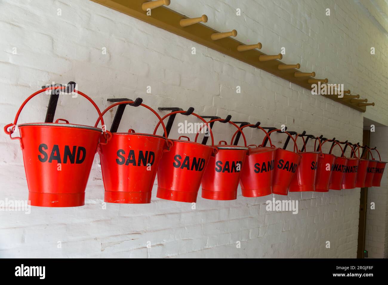 Eine Reihe roter Feuereimer Wasser und Sand im Fort Nelson Royal Armouries Hampshire England Stockfoto