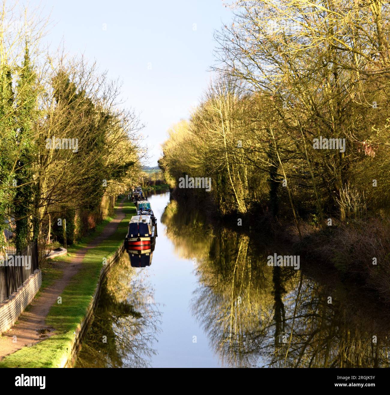 Helles Morgenlicht auf dem Oxford Canal, das im stillen Wasser die Boote und Bäume des Kanals reflektiert Stockfoto