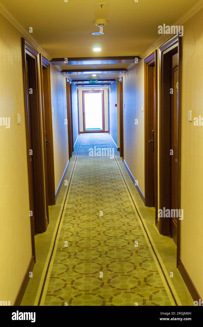 Langer Flur mit Zimmertüren und Teppich eines Hotels und Licht am Ende in Istanbul, Türkei Stockfoto