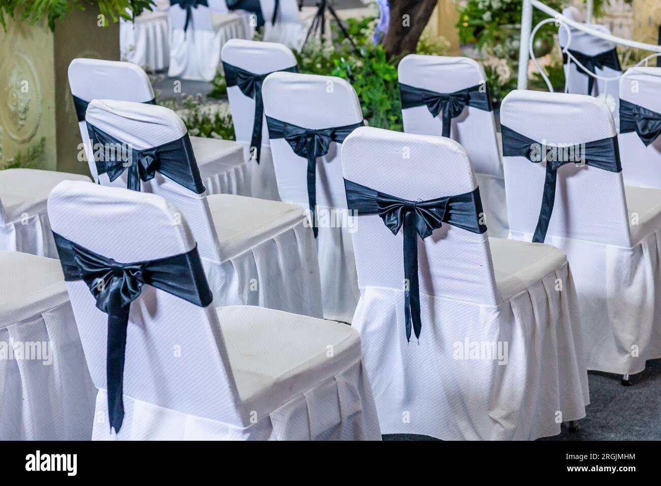Einrichtung des Veranstaltungsorts für Hochzeitsempfänge im Innenbereich mit einer ordentlichen Anordnung von Tischen und Stühlen Stockfoto