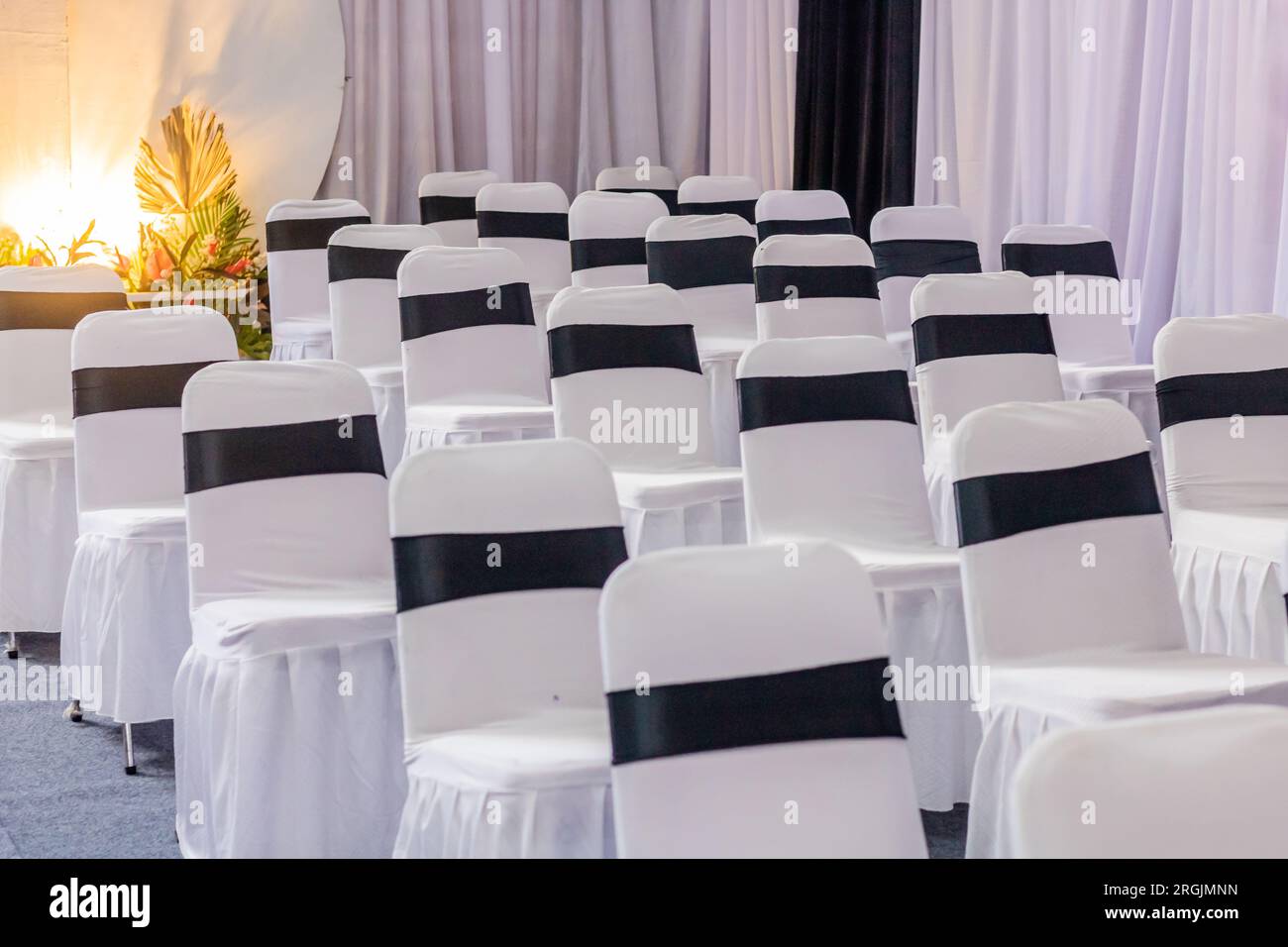 Einrichtung des Veranstaltungsorts für Hochzeitsempfänge im Innenbereich mit einer ordentlichen Anordnung von Tischen und Stühlen Stockfoto