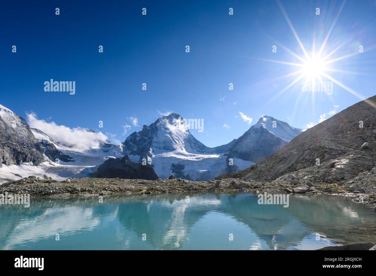 Dent Blanche mit sunstar-Spiegelung in einem Gletschersee Stockfoto