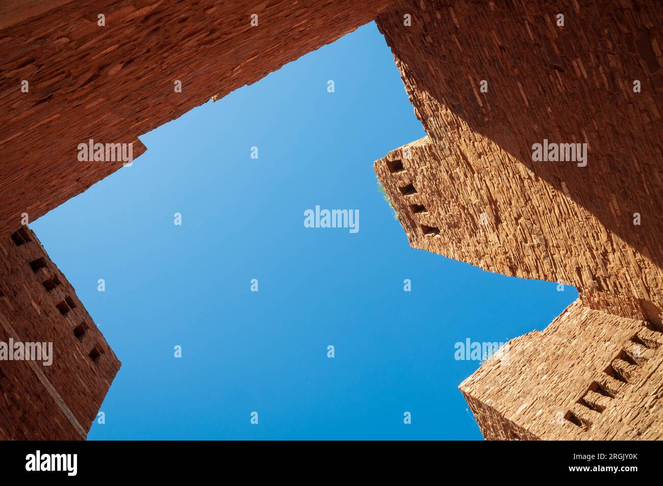 Ruinierte Sandsteinwände und eine abgestufte Wallplatte rahmen ein Stück blauen Himmels beim Salinas Pueblo Missions National Monument in New Mexico ein. Stockfoto
