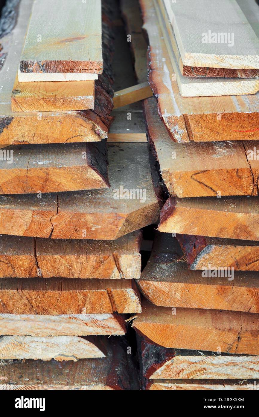 Neue gehobelte Holzbretter im Sägewerk gestapelt. Beschaffung und Verkauf von Baumaterial. Trockenes Holz. Holzbearbeitung. Hintergrund. Stockfoto