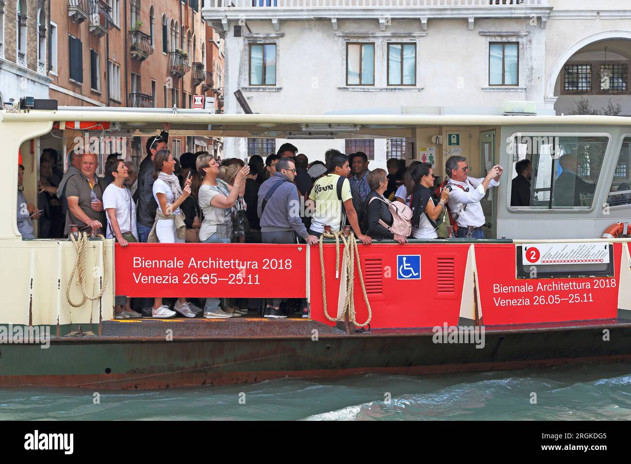 VENEDIG, ITALIEN - 18. MAI 2018: Dies sind nicht identifizierte Touristen, die enthusiastisch von einem Vaporetto aus Sightseeing machen. Stockfoto VENEDIG, ITALIEN - 18. MAI 2018: Dies sind nicht identifizierte Touristen, die enthusiastisch von einem Vaporetto aus Sightseeing machen. Stockfoto