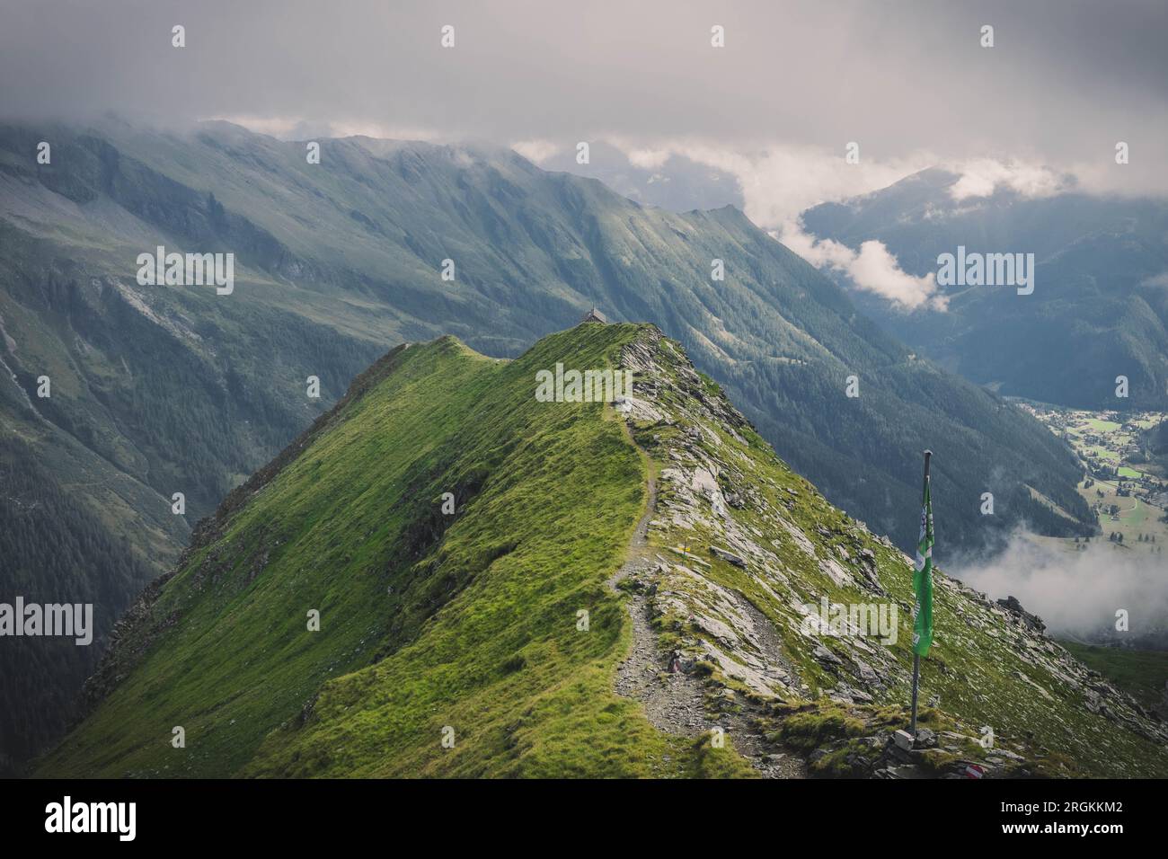 Ein wunderschöner Pfad in den Bergen, Hintergrund, im Hintergrund wunderschöne Wolken, blauer Himmel, Berge und ein Blick in das Tal Stockfoto