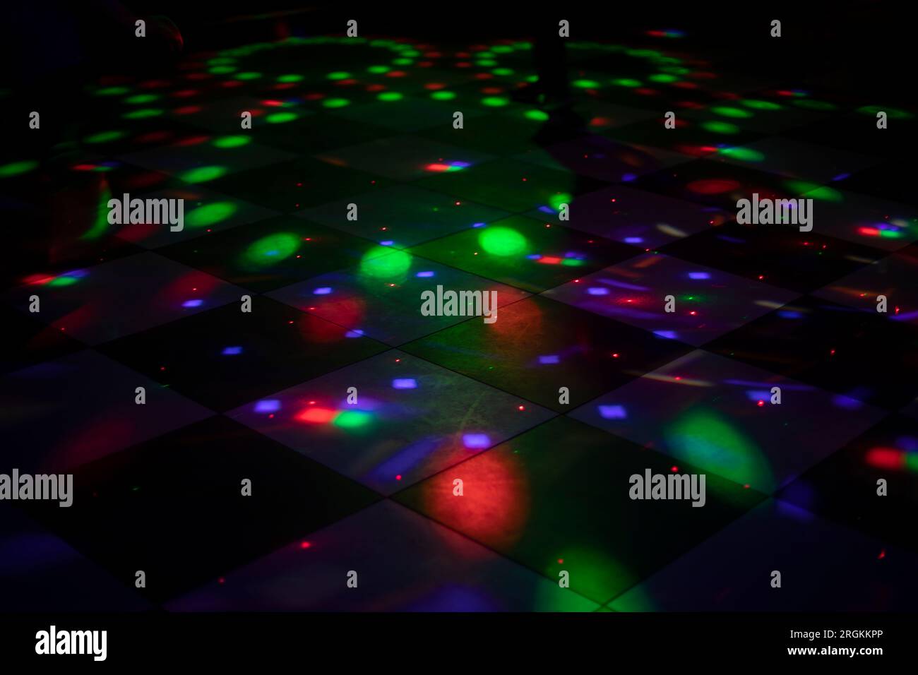 Farbmusik in der Disco. Tanzfläche im Club. Innenraum mit Beleuchtung. Flecken in verschiedenen Farben auf dem Boden. Stockfoto