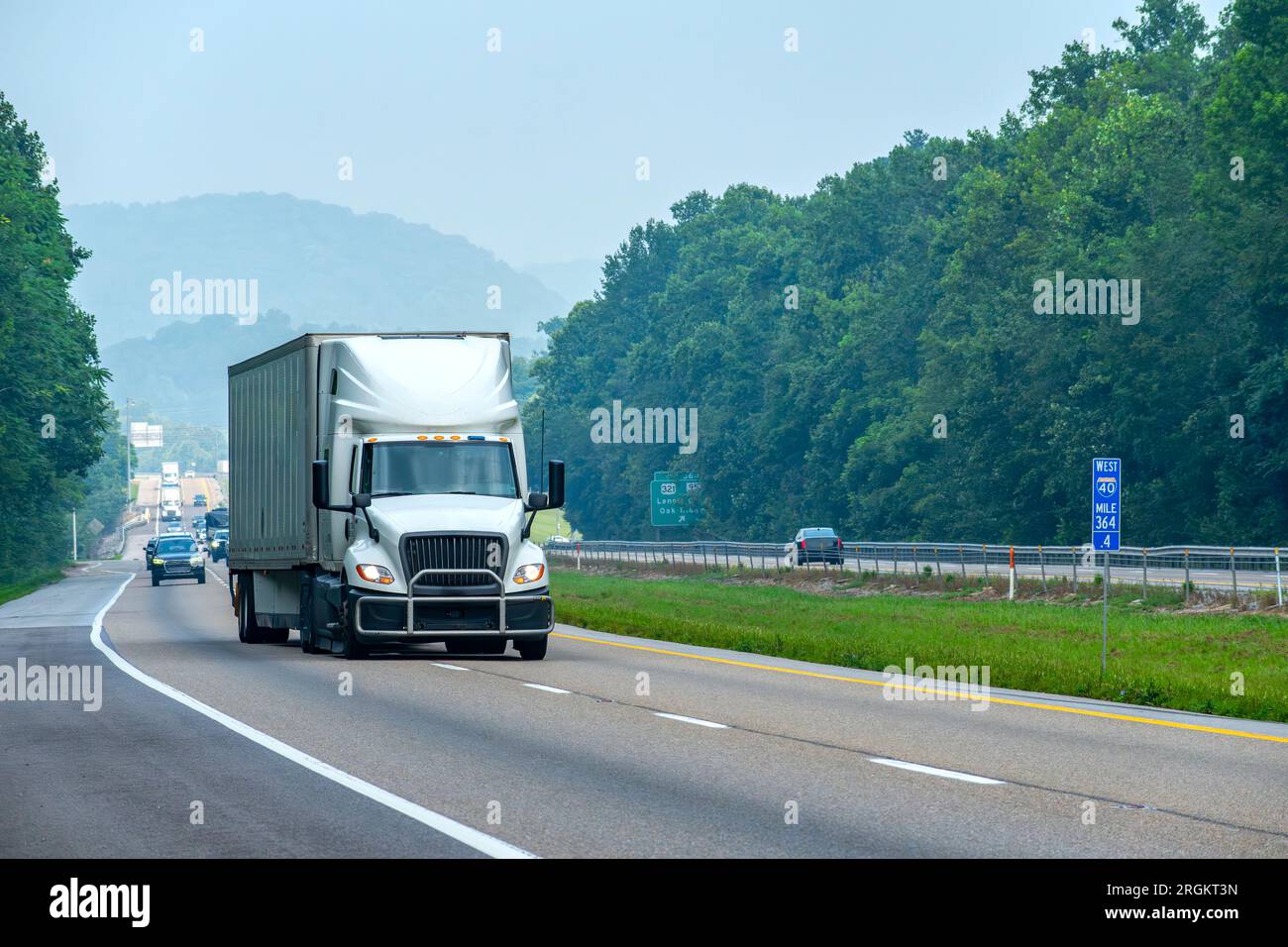 Horizontale Aufnahme eines weißen Kastenlasters, der auf einer Autobahn die Spur wechselt. Stockfoto