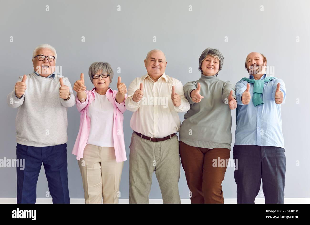 Porträt eines glücklichen, lächelnden älteren Menschen, der in die Kamera schaut und ein Daumenschild zeigt. Stockfoto