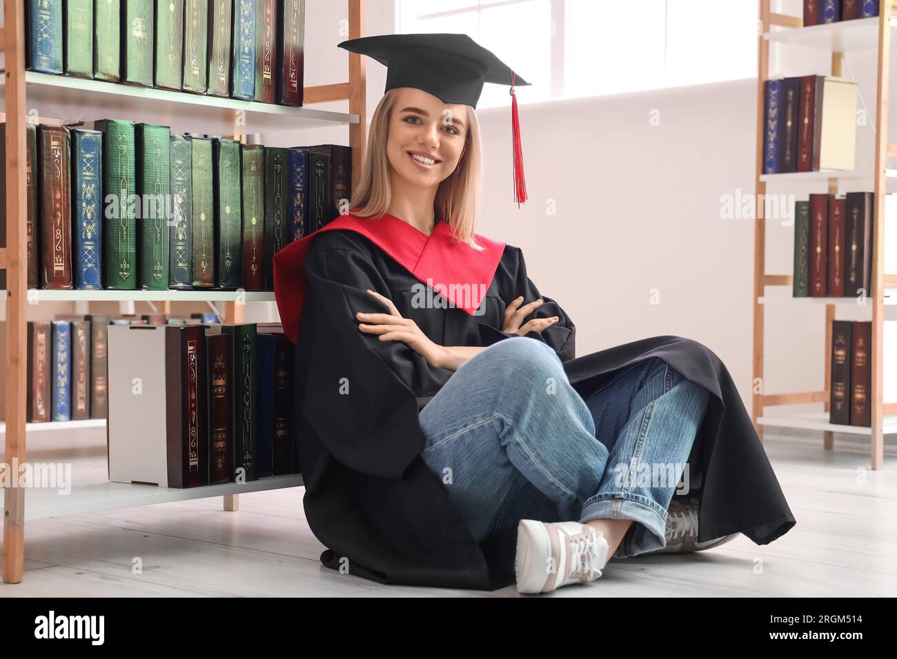 Weibliche Studentin, die in der Bibliothek sitzt Stockfoto