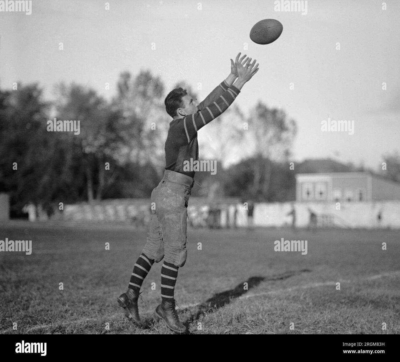 Ein College-Footballspieler, der sich einen Fußball einfängt. 1925 Stockfoto