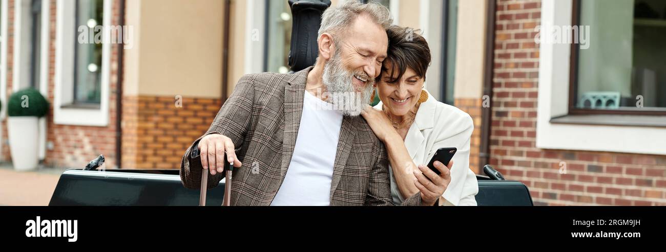 Banner, älteres Paar, glücklicher älterer Mann mit Smartphone, der mit einer Frau mit Gadget sitzt Stockfoto