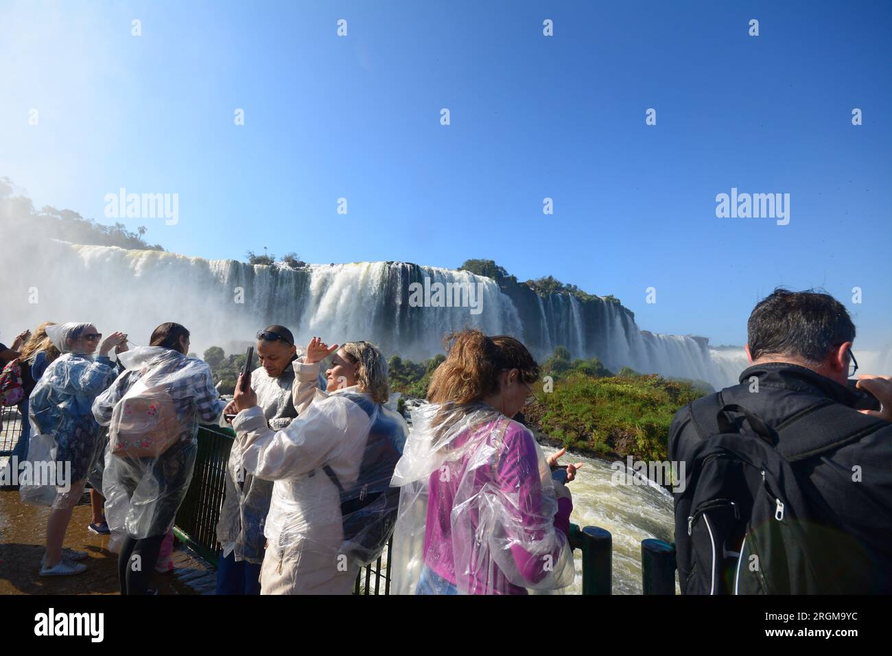 Touristen an den Iguazu Falls, einem der großen Naturwunder der Welt, an der Grenze von Brasilien und Argentinien Stockfoto