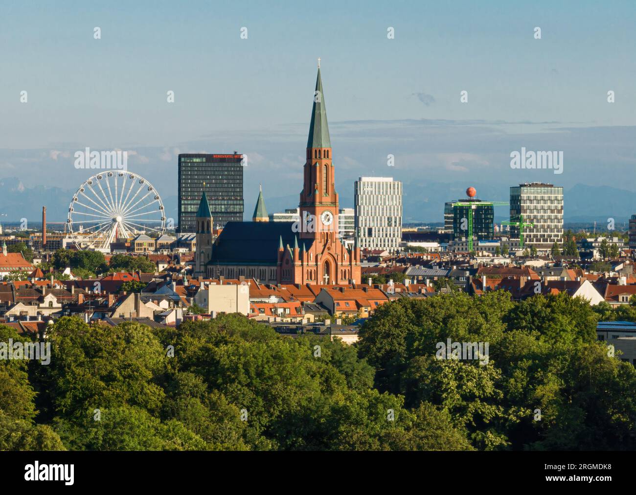 MÜNCHEN - 10. AUGUST 2023: ST. Johann Baptistenkirche und das neue Münchner Stadtviertel Werksviertel mit dem Hi-Sky Riesenrad. Stockfoto