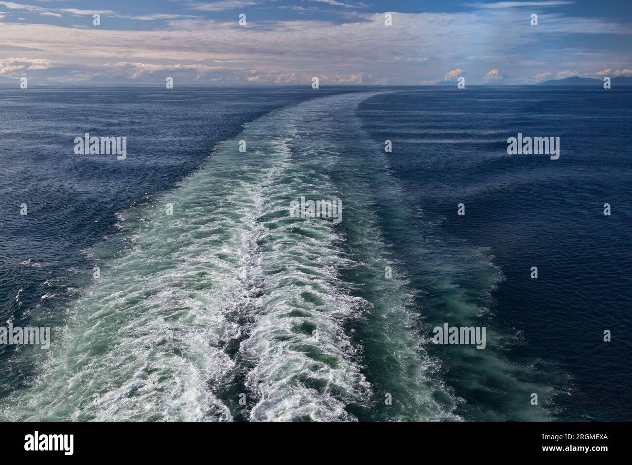 Stern, Turbulent Wake verschwindet in der Ferne, untergehende Sonne, reflektierende Wolken, untere Clarence Straße, Pazifik, Alaska. Stockfoto