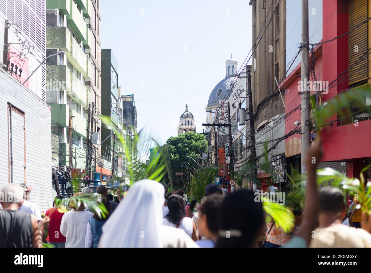 Salvador, Bahia, Brasilien - 02. April 2023: Dutzende von Menschen, die sich an den Katholizismus halten, werden gesehen, wie sie an der Palmensonntagsprozession in der Stadt teilnehmen Stockfoto