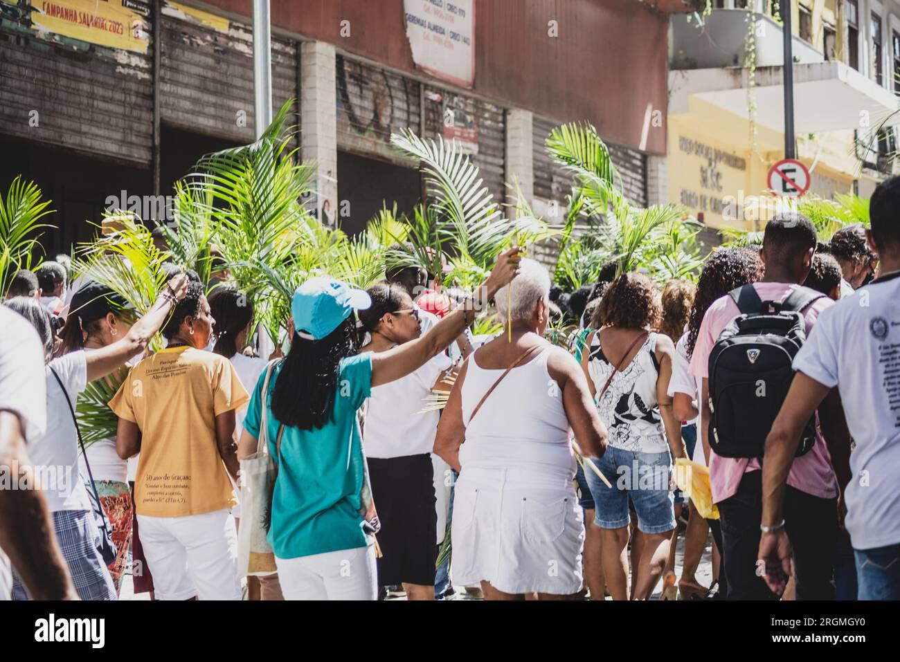 Salvador, Bahia, Brasilien - 02. April 2023: Dutzende von Menschen, die sich an den Katholizismus halten, werden gesehen, wie sie an der Palmensonntagsprozession in der Stadt teilnehmen Stockfoto