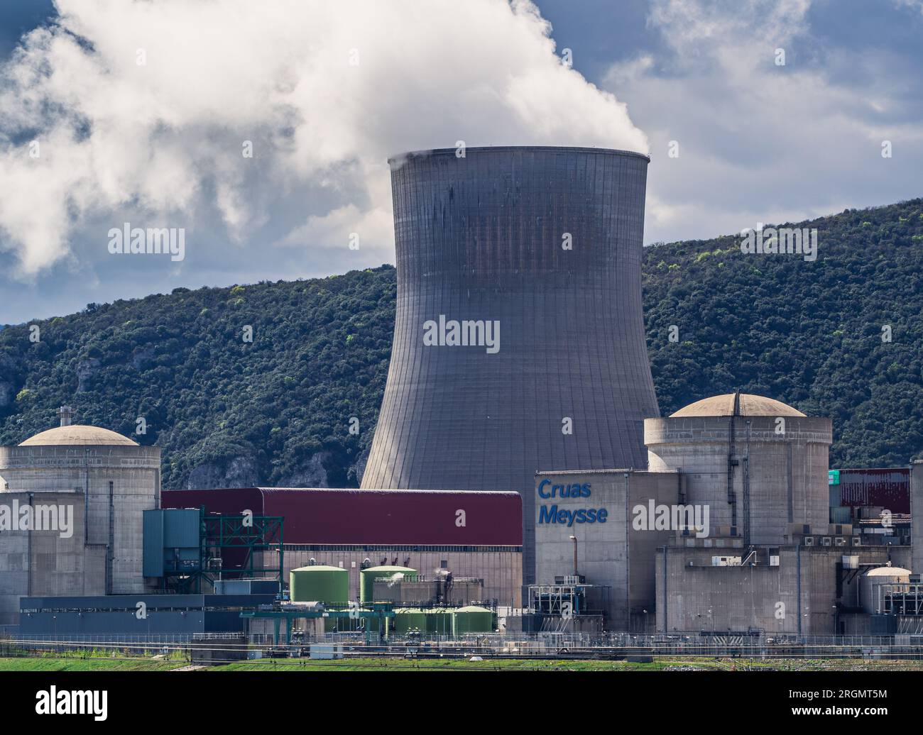 Cruas, Frankreich - 4. April 2023: Blick über den Fluss im Kernkraftwerk (CNPE Cruas-Meysse) vor Kalksteingestein im Hintergrund. Stockfoto