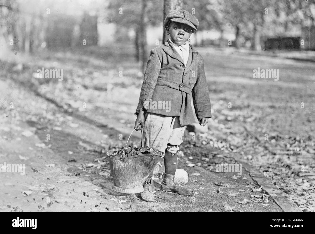 Ein junger afroamerikanischer Junge mit einem Eimer Kohle. 1909-1932 Stockfoto