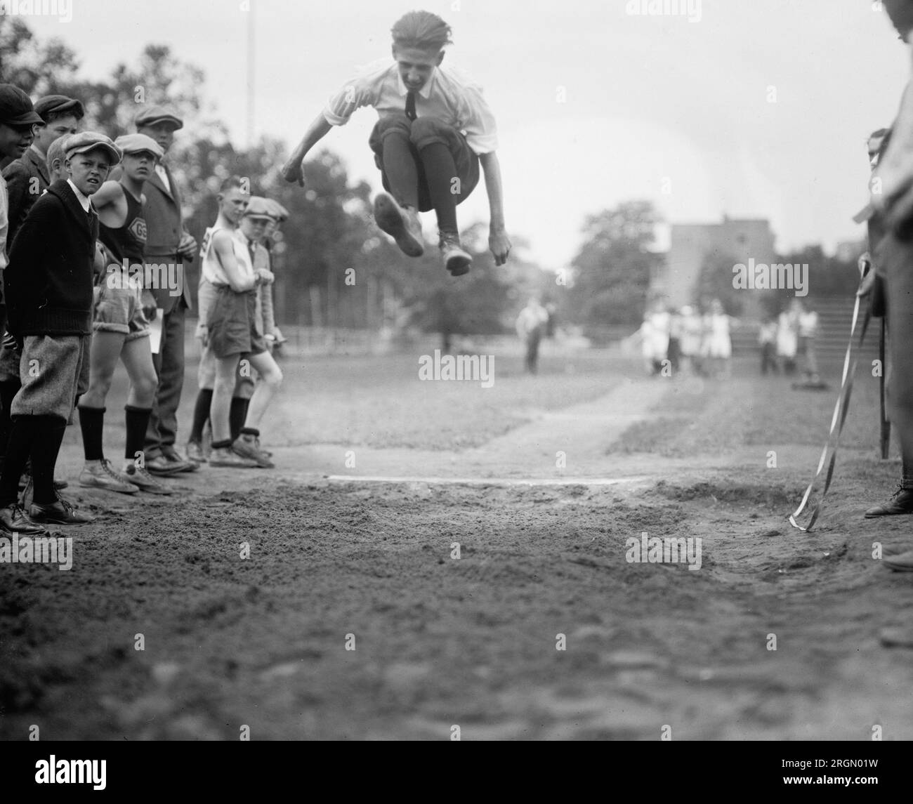 Leichtathletik-Sportler aus der Grundschule, die an einem Langsprung-Wettkampf teilnehmen. 1924 Stockfoto