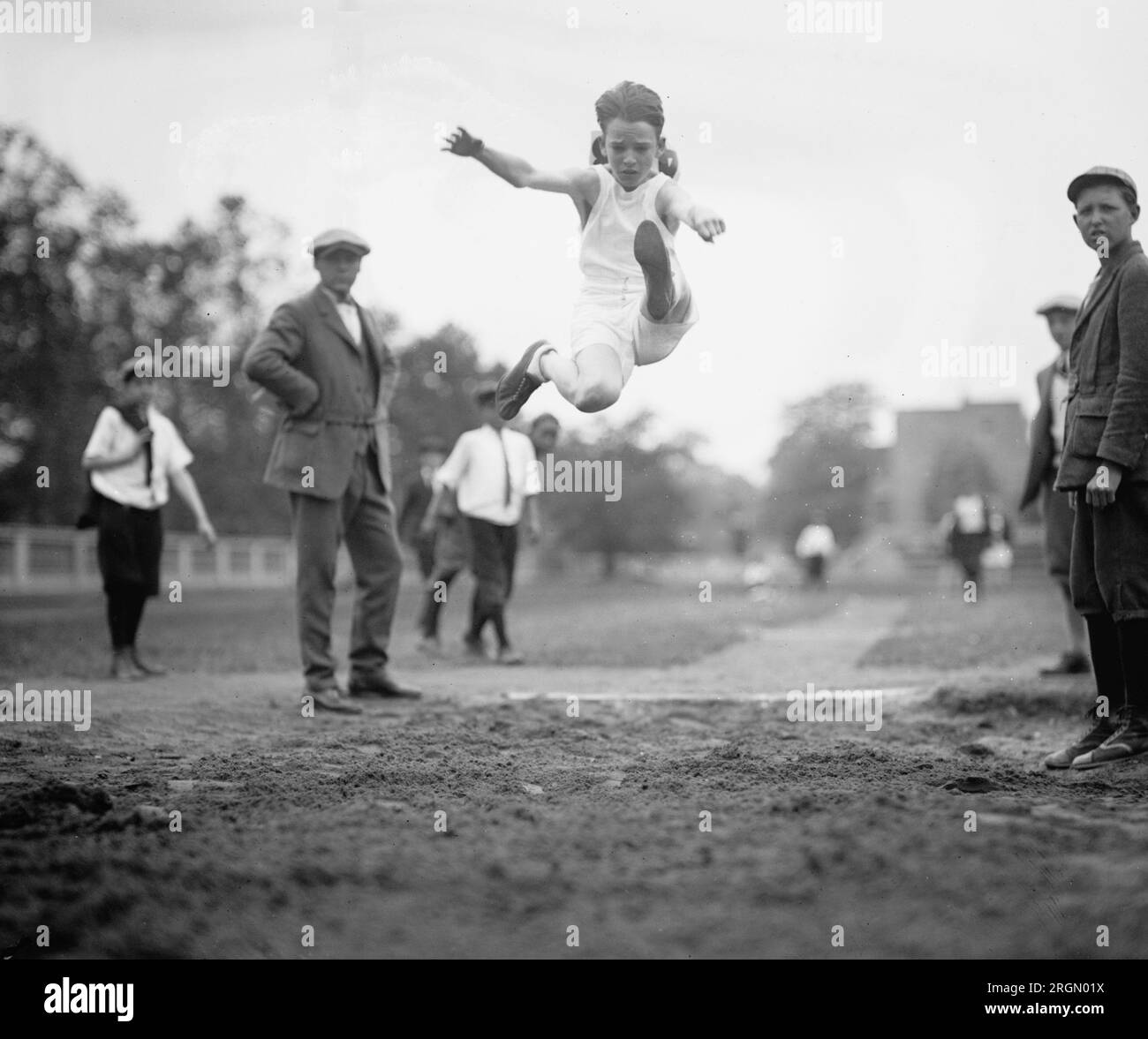 Leichtathletik-Sportler aus der Grundschule, die an einem Langsprung-Wettkampf teilnehmen. 1924 Stockfoto