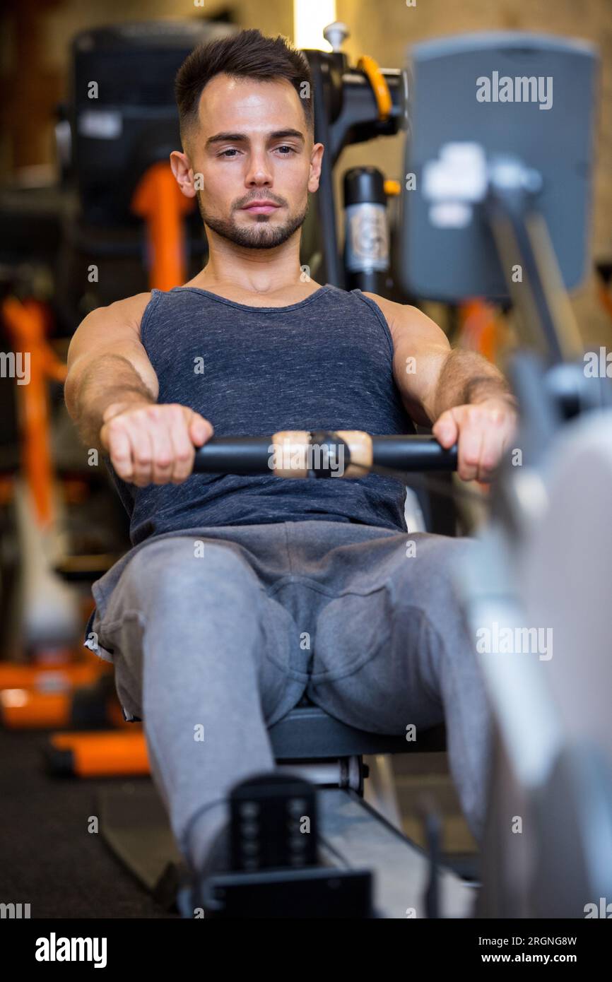 Ein Mann im Fitnessstudio am Rudergerät Stockfoto