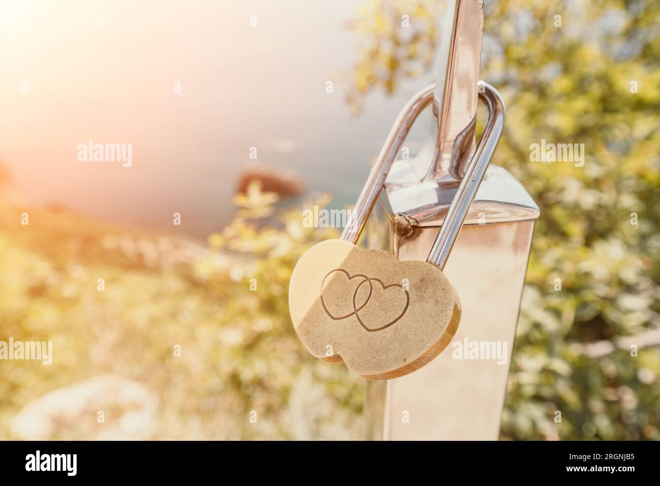 Hochzeitsherz Golden Lock auf Edelstahlzaun. Valentinstag. Symbol der ewigen Liebe. Eine Hochzeitstradition auf der ganzen Welt, um das Schloss zu blockieren Stockfoto