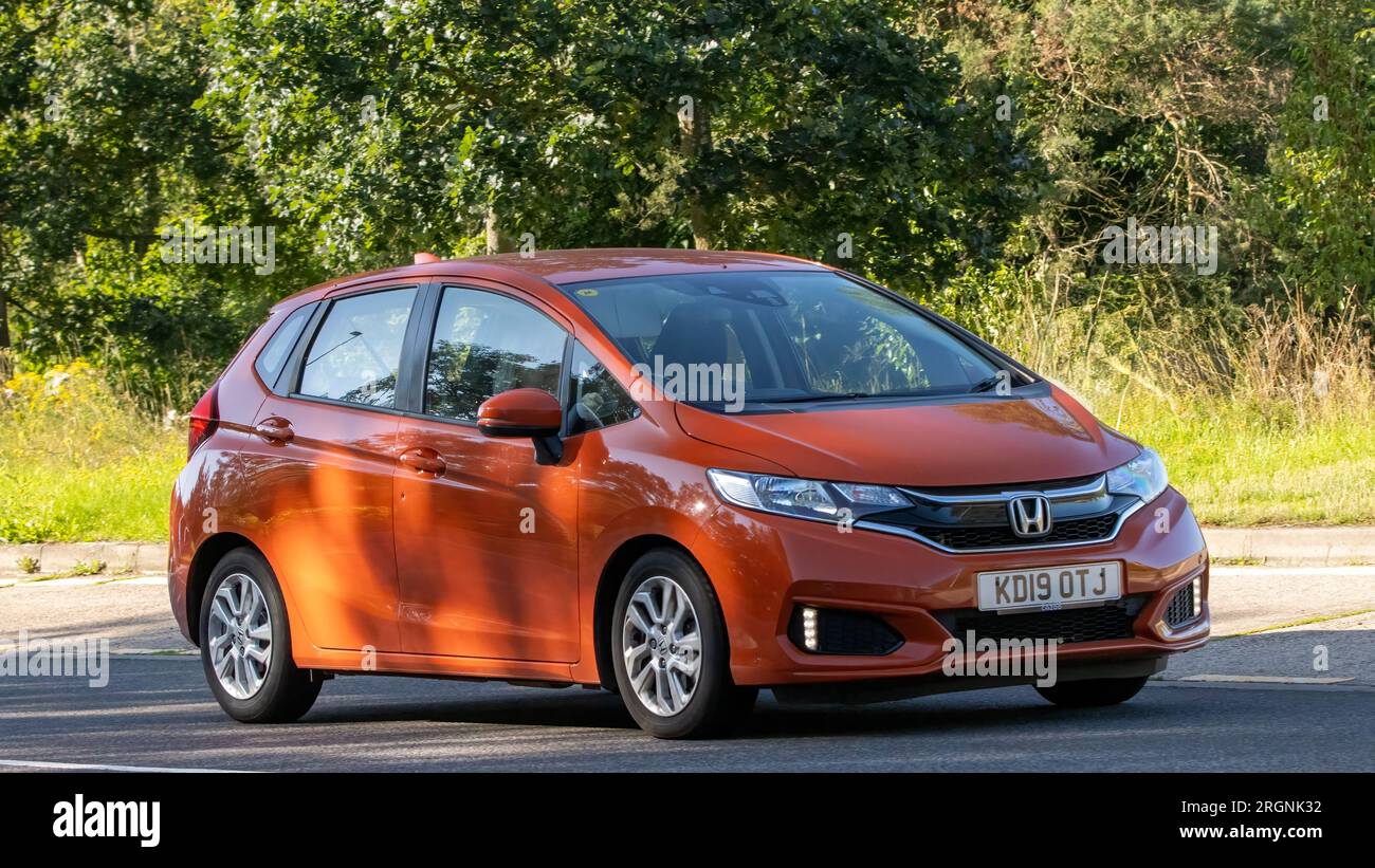 Milton Keynes, Großbritannien - August 10. 2023: 2019 orangefarbener Honda Jazz, der auf einer englischen Landstraße fährt. Stockfoto