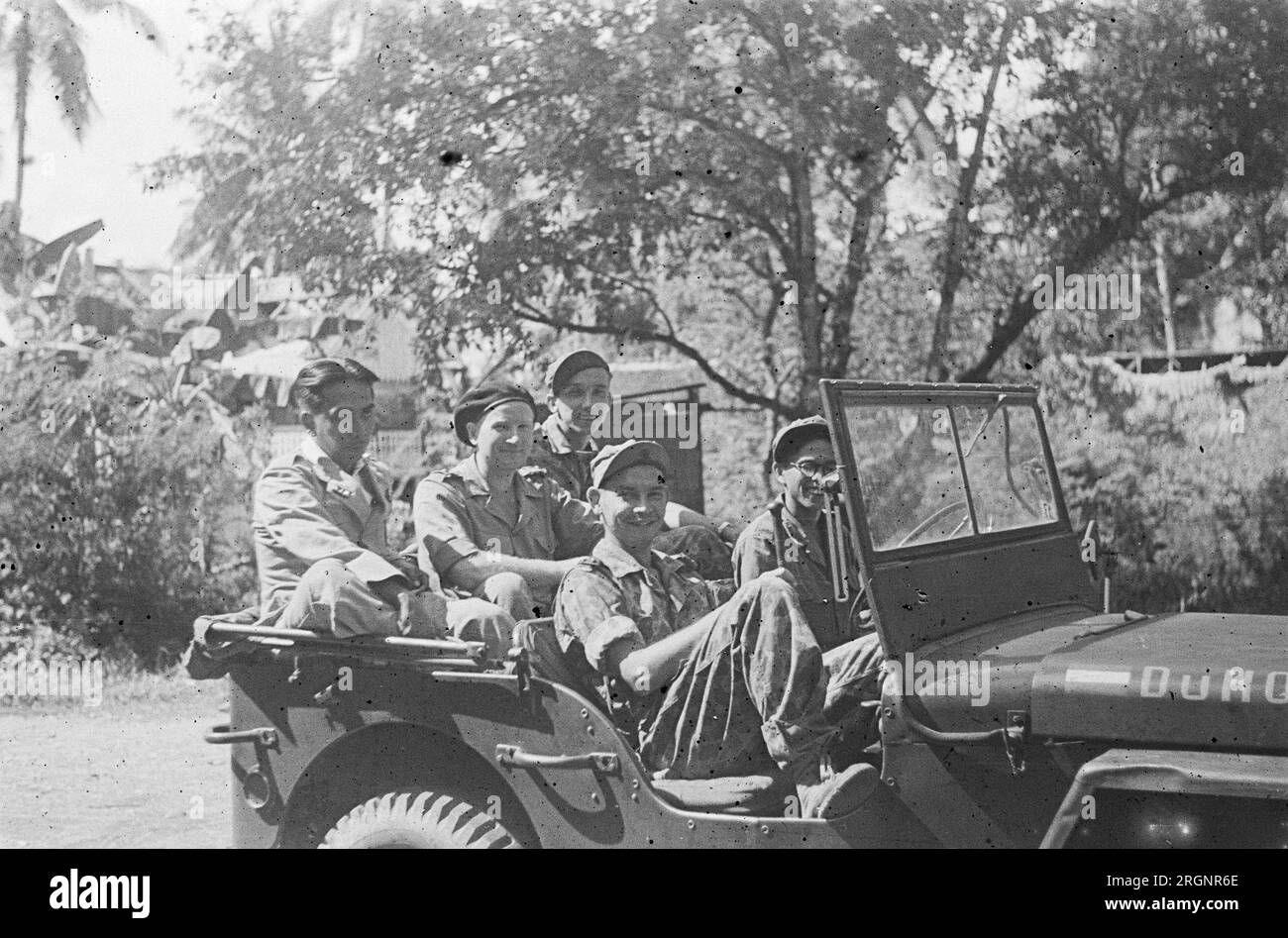 Vier holländische Soldaten posieren in einem Jeep. Der fünfte Mann links scheint ein republikanischer Kriegsgefangener zu sein. 1947 Stockfoto