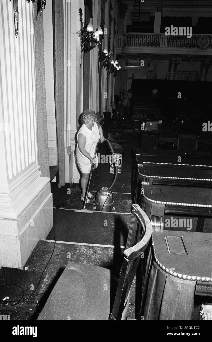 Aktivitäten im Repräsentantenhaus im Zusammenhang mit der Installation von Frischluftanlagen, Arbeiter beseitigen das Chaos; Frau benutzt einen Staubsauger ca. 14. August 1972 Stockfoto