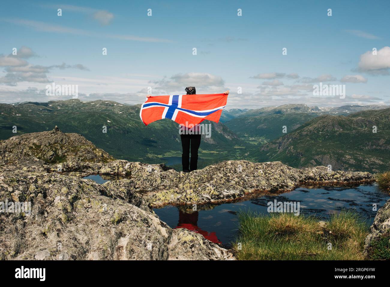 Person mit norwegischer Flagge in den Bergen in Norwegen Stockfoto