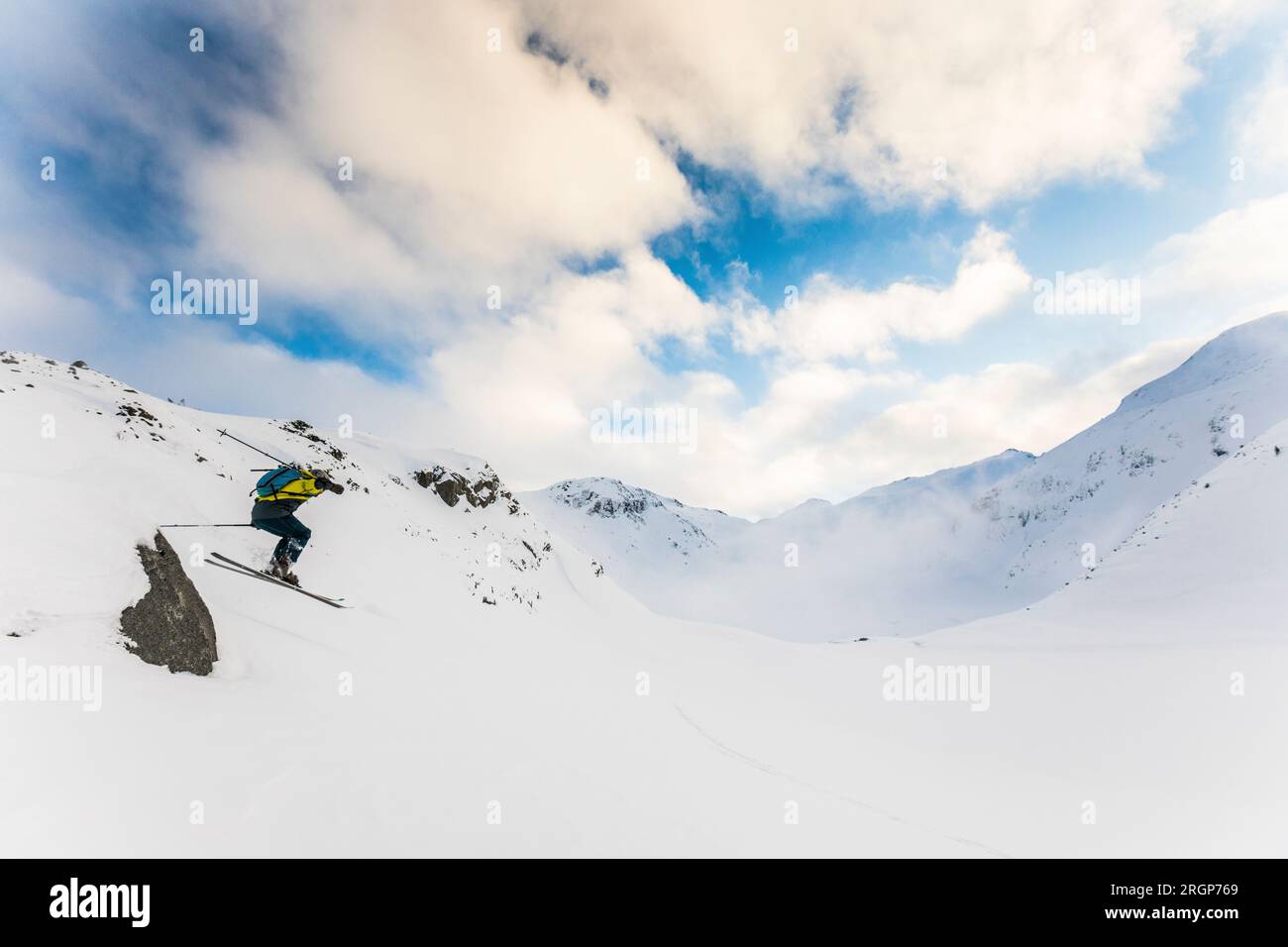 Ein Skifahrer im Hinterland findet einen Sprung von einem kleinen Felsen Stockfoto