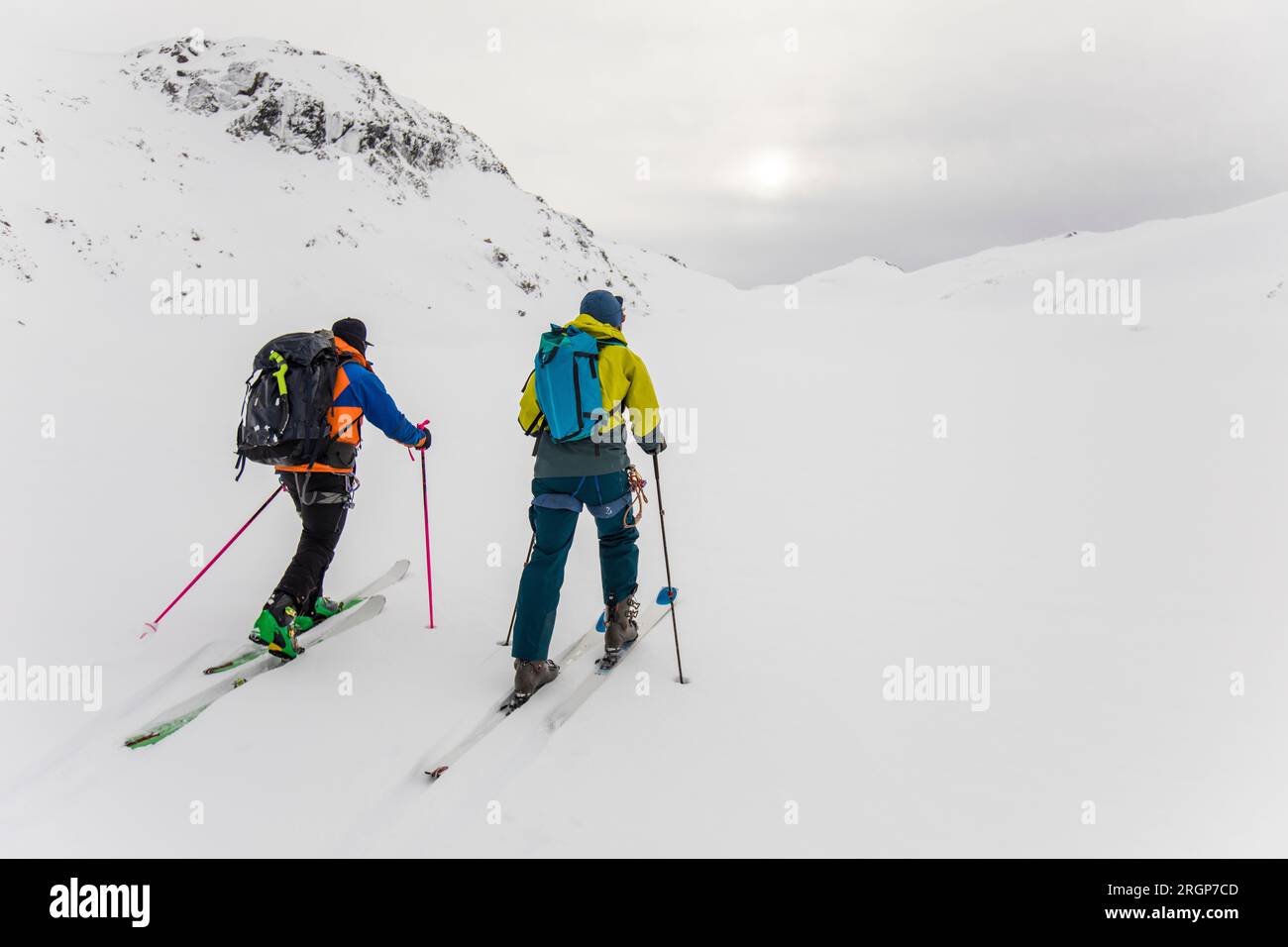 Rückansicht von zwei Männern mit Rucksäcken auf Skitouren in den Bergen Stockfoto