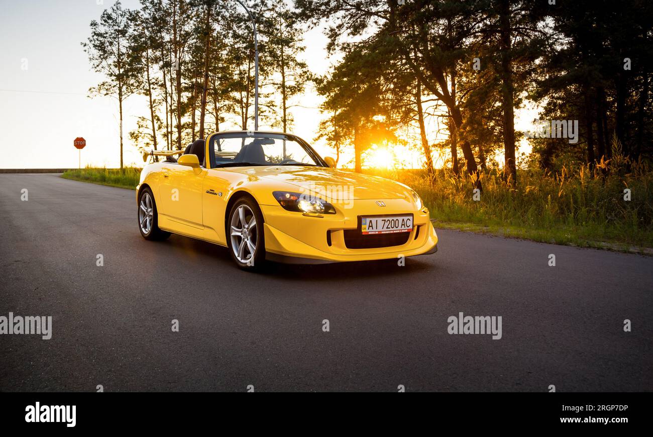 Gelber Honda S2000 Type S auf einer bewaldeten Straße abgestellt Stockfoto