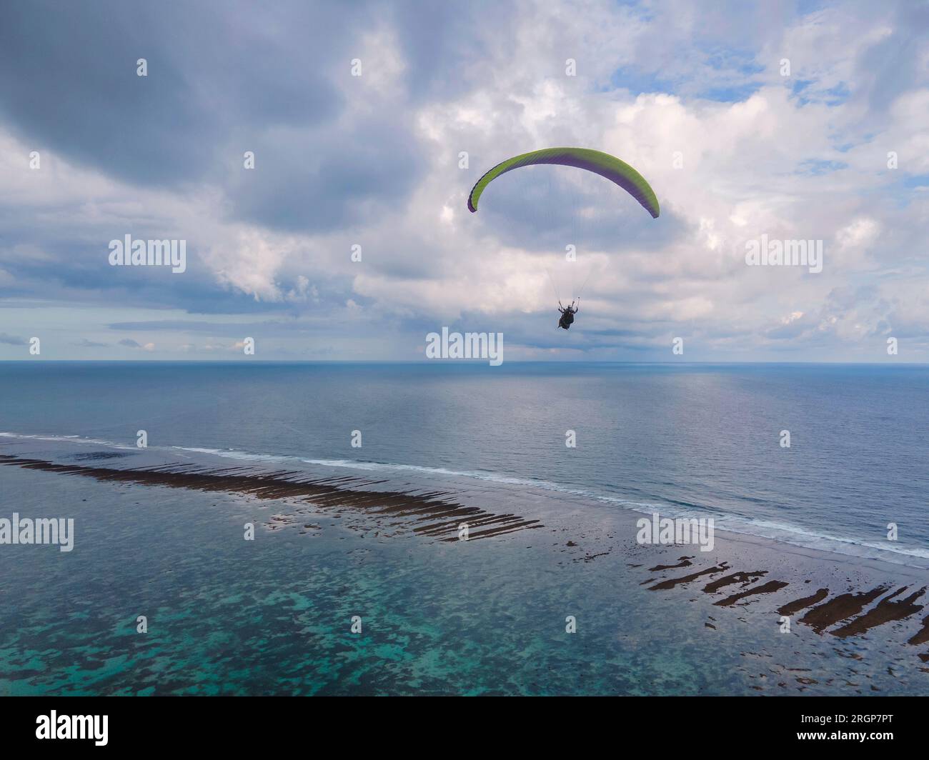 Gleitschirmfliegen hoch über dem Meer an sonnigen Tagen Stockfoto