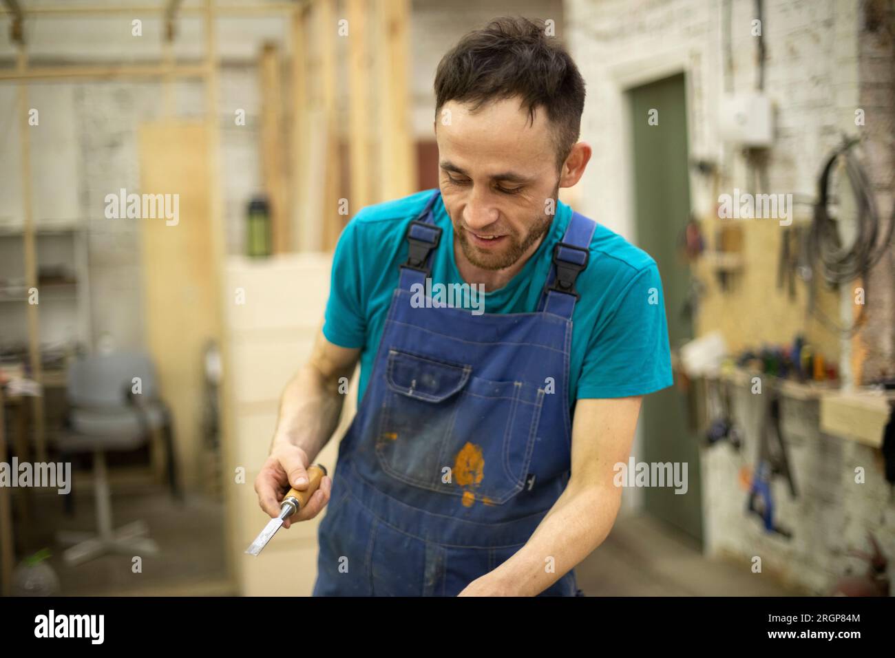 Der Kerl lächelt bei der Arbeit. Mann in Arbeitskleidung. Stockfoto