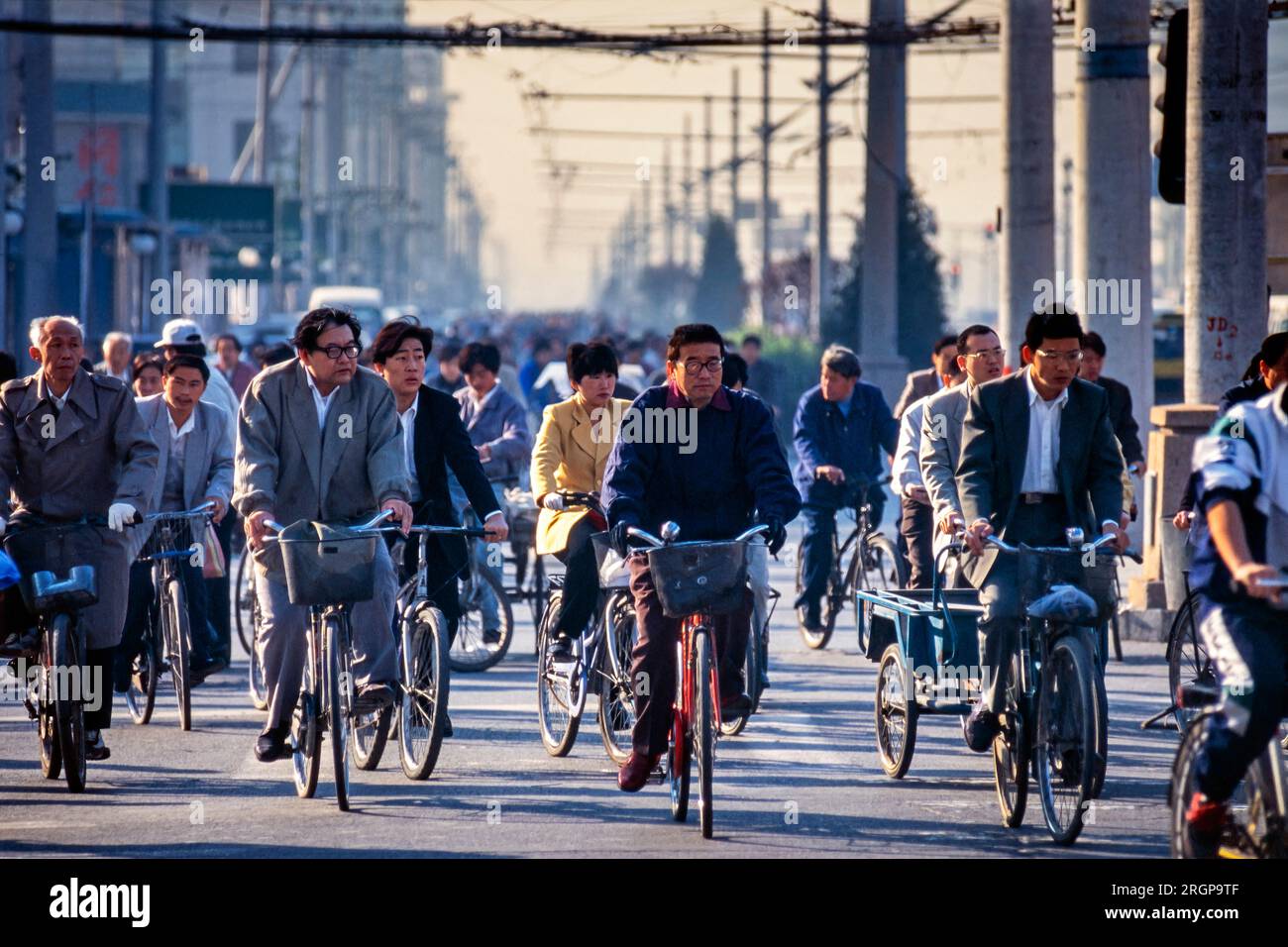 Fahrräder und Radfahrer an der Straßenkreuzung in Peking, China Stockfoto