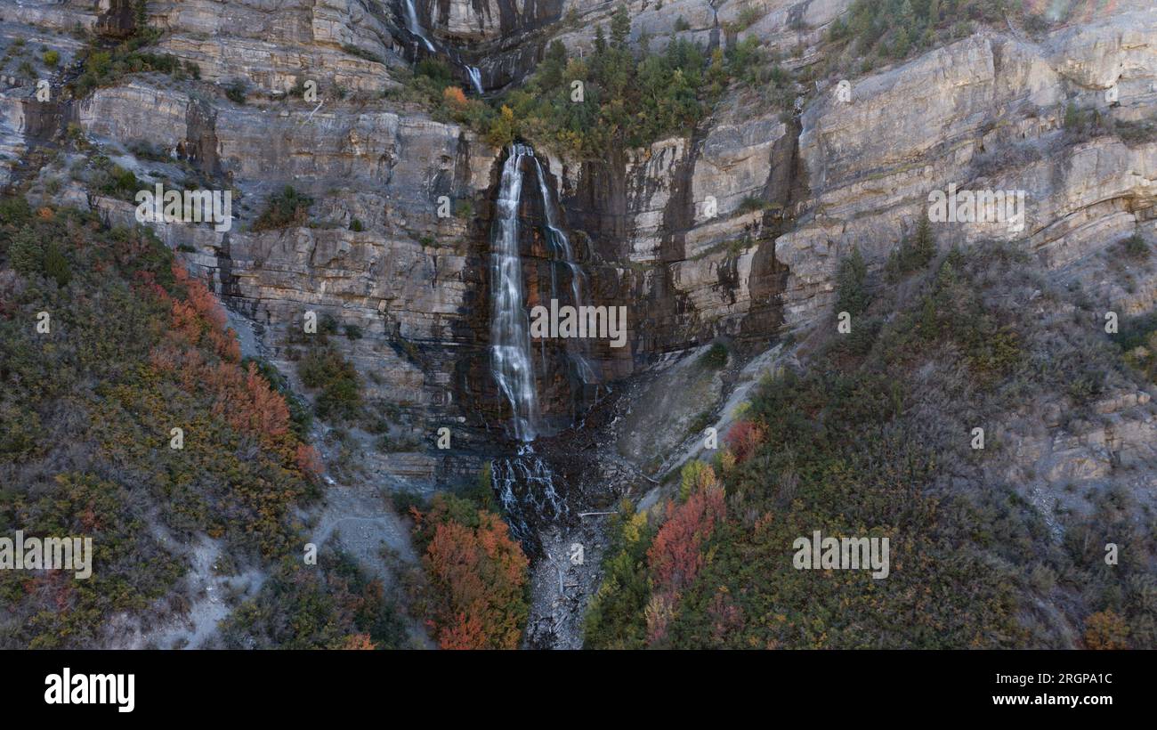 Der Wasserfall fällt im Herbst mit Felsen und Bäumen hinunter Stockfoto