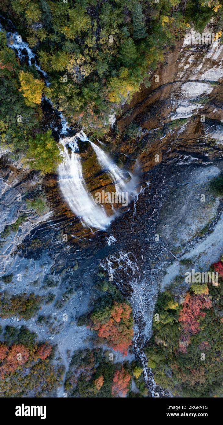 Drohnenschuss von der Spitze des Wasserfalls über die Klippe mit Herbstblättern Stockfoto