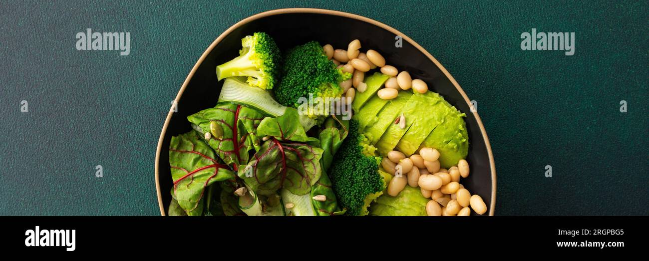 Gesundes Frühstück Banner, Mangold Salat mit Bohnen und Gurken, Avocado und Brokkoli mit verschiedenen Samen, ein Teller mit Essen Stockfoto