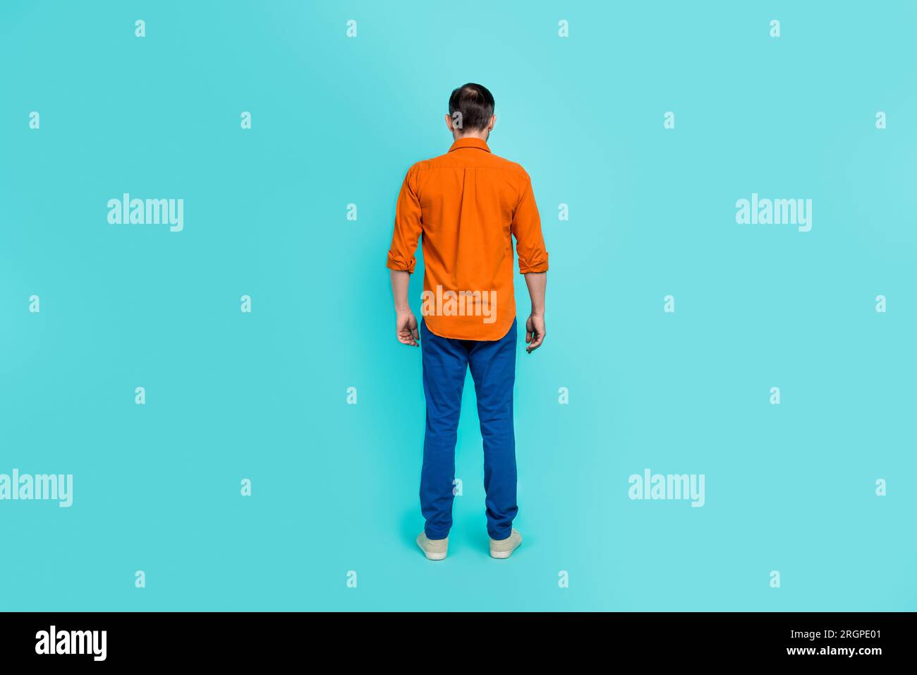 Ganzkörperfoto eines Geschäftsmannes Alterspensionär trägt orangefarbenes Hemd Denimjeans Freizeitkleidung isoliert auf cyanfarbenem Hintergrund Stockfoto