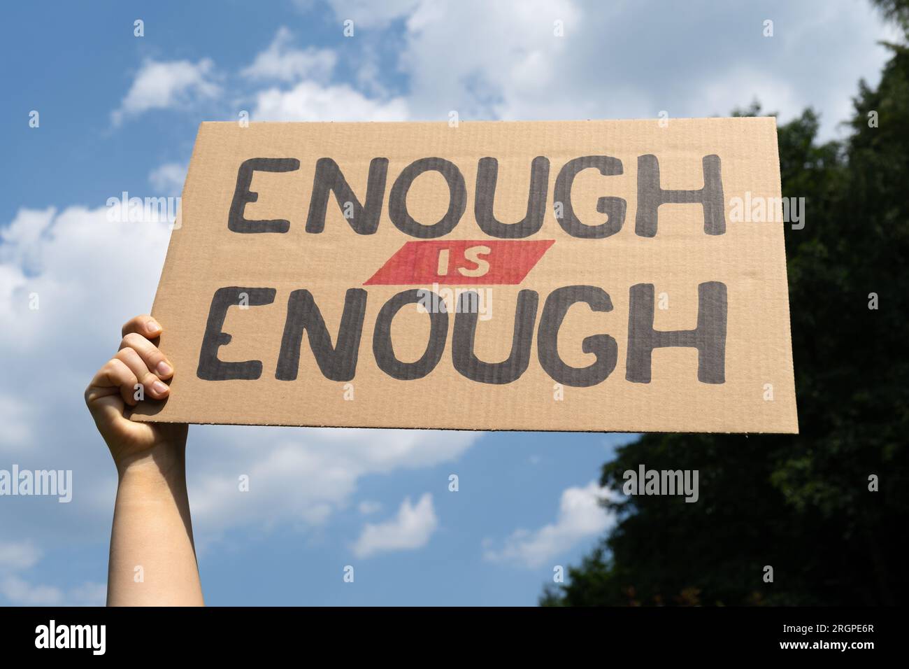 Eine Frau, die ein Plakatschild hält, reicht. Kartonbanner bei der Demonstration der Protestkundgebung. Fordern Sie Veränderungen, fordern Sie Maßnahmen in Fragen der sozialen Gerechtigkeit. Stockfoto