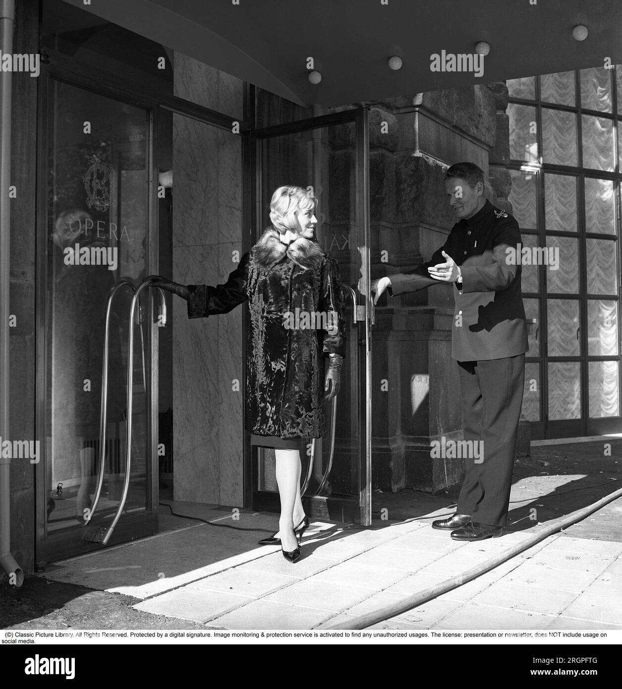 Service in den 1960ern Eine junge, modische Frau steht vor dem Eingang des Restaurants Operakällaren in Stockholm mit einem Portier, der galant die Tür hochhält. Schweden 1962. Kristoffersson Ref CV87-5 öffnet jemandem die Tür Stockfoto