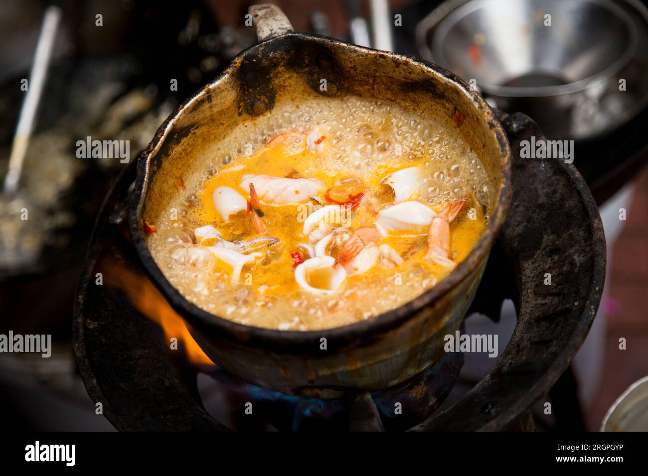 Tintenfische mit rotem Curry an einem Street Food Stand in Bangkok, Thailand. Stockfoto