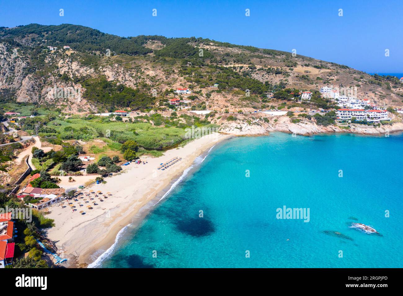 Schönes griechisches Fischerdorf Armenistis an einem ruhigen Sommermorgen. Hafen mit lokalem Strand in transparentem klarem Wasser in Ikaria, Griechenland Stockfoto