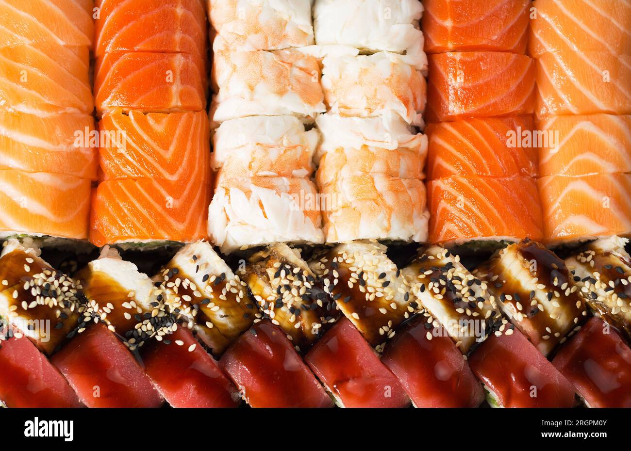 Japanisches Essen, Brötchen in Riesengarnelen, Brötchen in geräuchertem Aal mit Unagi-Sauce und Philadelphia-Brötchen mit Lachs Stockfoto