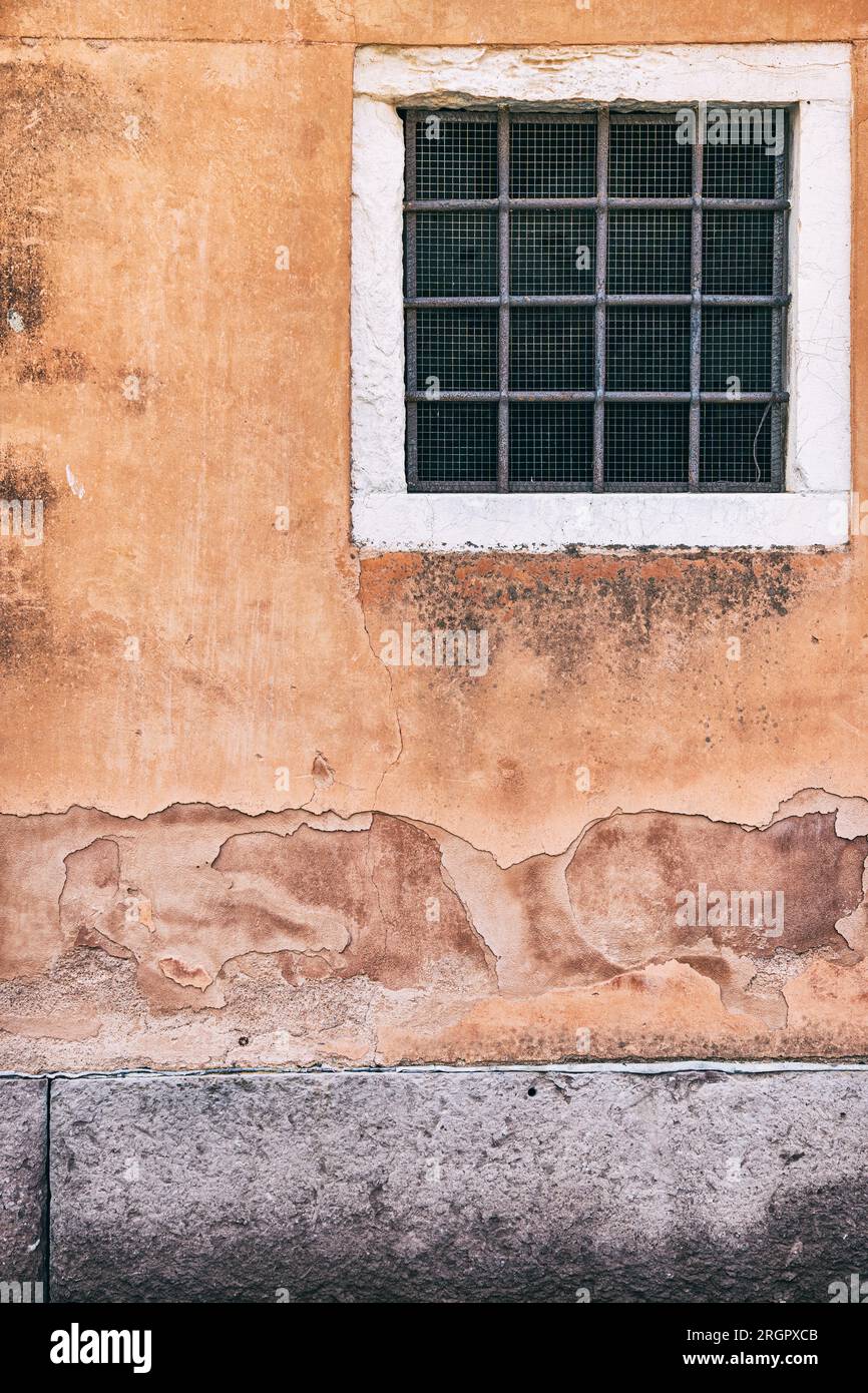 Alte rote Backsteinwand mit zwei rostigen Grillfenstern. Stockfoto